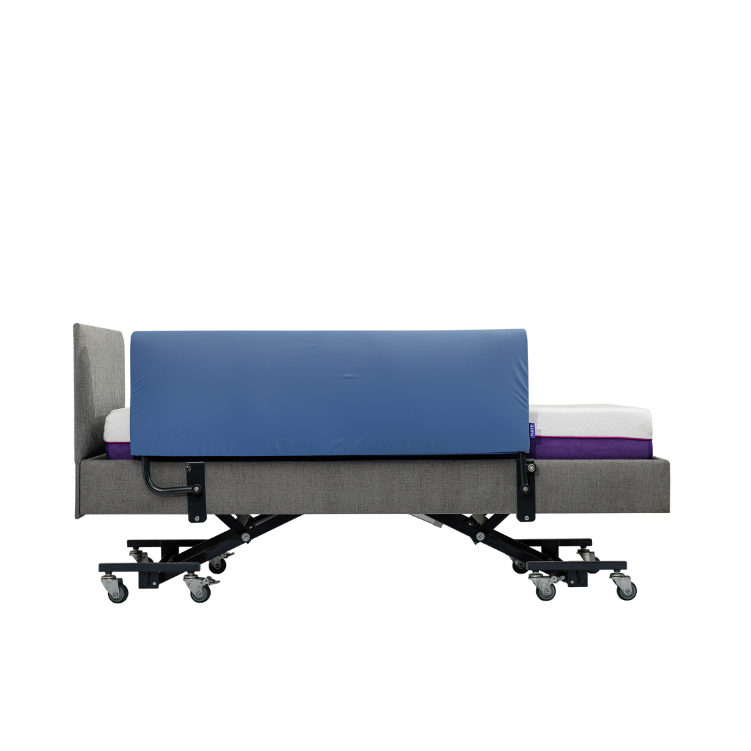 Side view of an iCare Medical Bed Safety Rail attached to a hospital-style bed, with a blue safety rail for fall prevention, gray frame, purple mattress layer, and caster wheels on each leg, isolated on white background.